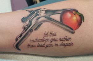 tattoo of a speculum holding a nectarine with the text "Let this radicalize you rather than lead you to despair"